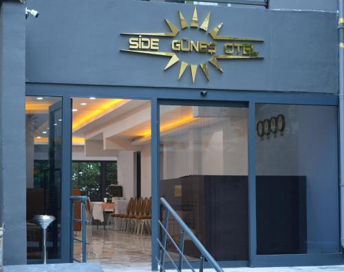 a building with a sign that reads she fires off at Side Güneş Otel in Side