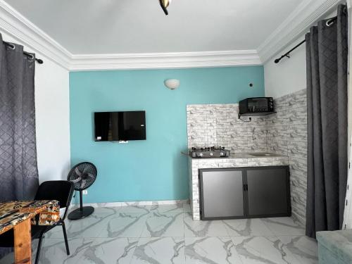 a living room with a blue wall and a stove at Studio Villa Hortensia in Dakar