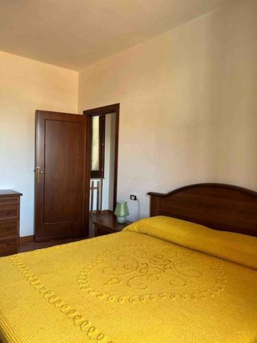 a bedroom with a bed with a yellow blanket at Casa nuova indipendente in Sardegna in Laerru