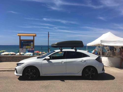 a white car with a surfboard on top of it at Casa nuova indipendente in Sardegna in Laerru