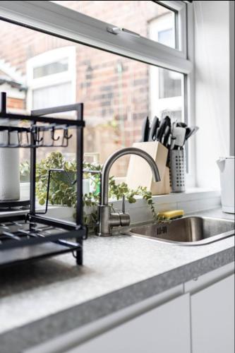 a kitchen counter with a sink and a window at Home Away From Home Local To A Lot Of Amenities in Stoke on Trent