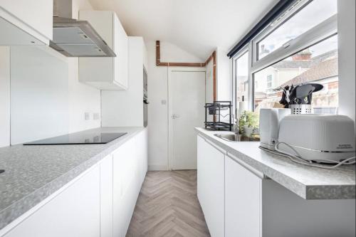 a kitchen with white cabinets and a toaster on a counter at Home Away From Home Local To A Lot Of Amenities in Stoke on Trent