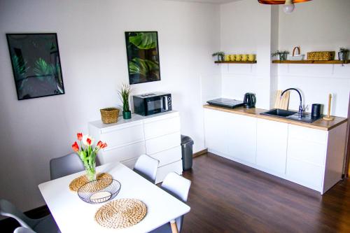 een kleine keuken met een tafel en een magnetron bij Srokówka Resort in Dąbrówka