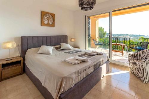 a bedroom with a large bed and a balcony at Casa Alegría Casa premium piscina comunitaria in S'agaro