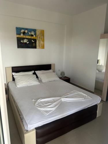 Schlafzimmer mit einem Bett mit weißer Bettwäsche in der Unterkunft Villa Spartandom in Gerakini