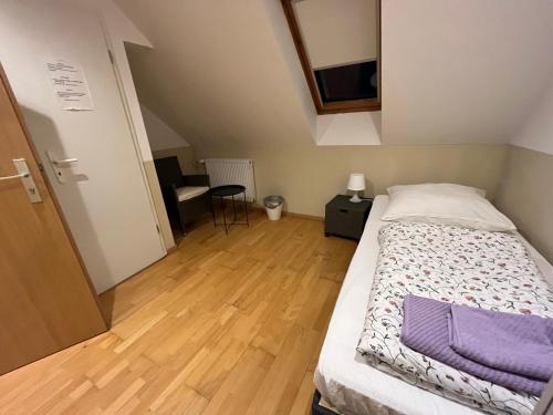 a small bedroom with a bed and a wooden floor at Einzelzimmer (16) in Meine