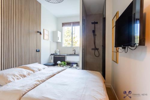 Schlafzimmer mit einem Bett und einem Flachbild-TV in der Unterkunft Neuilly sSeine - Inkermann in Neuilly-sur-Seine