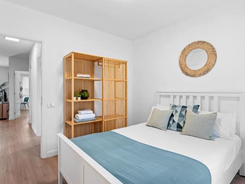 1 dormitorio con cama y estante para libros en Elegant apartment with private workspace, en Candelaria
