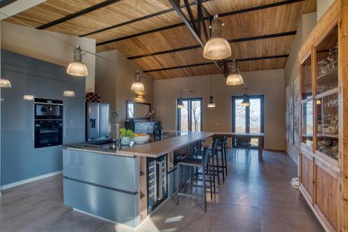 an open kitchen with a large island with bar stools at PaterMater b&b - La stanza di Luna in CastellʼAzzara