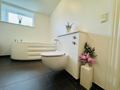 a bathroom with a white toilet and a bath tub at aday - Modern and Charming 5 bedrooms Villa 