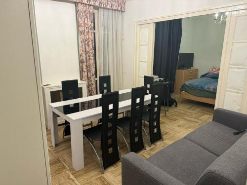 un salon avec une table, des chaises et un canapé dans l'établissement Grand appartement Michel-Ange, à Paris