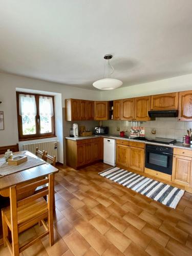 cocina grande con armarios de madera y mesa en Casa Lorenzo en Sondalo