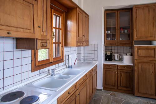 una cucina con mobili in legno e un lavello di 3 Olive Trees - Sithonia a Ormília