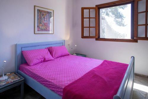 una camera con letto viola e finestra di 3 Olive Trees - Sithonia a Ormília