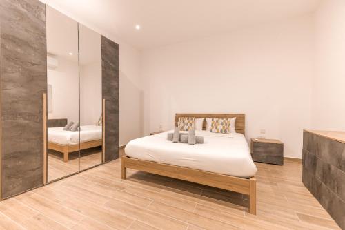 a bedroom with a large bed and a mirror at ORSOLA - New 2 BEDROOM Apartment in Valletta