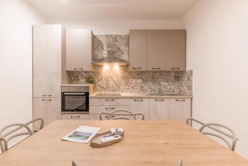 Una cocina con una mesa y sillas de madera. en ORSOLA - New 2 BEDROOM Apartment, en La Valeta