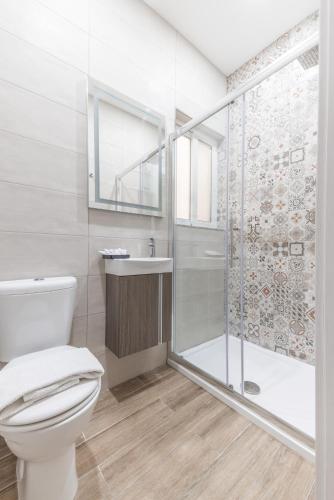 a bathroom with a shower and a toilet and a sink at ORSOLA - New 2 BEDROOM Apartment in Valletta
