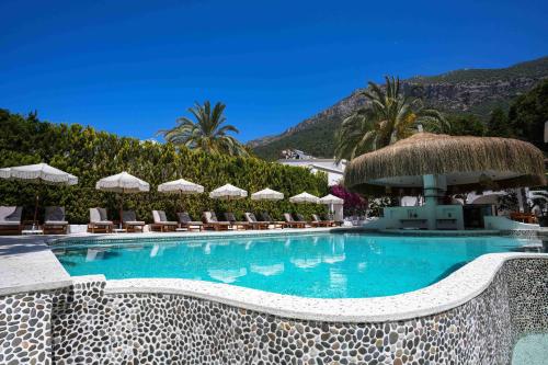 a swimming pool with chairs and umbrellas at Kassandra Boutique Hotel in Oludeniz