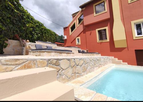 a house with a swimming pool next to a building at GKK House private swimming pool luxury house in Skriperón