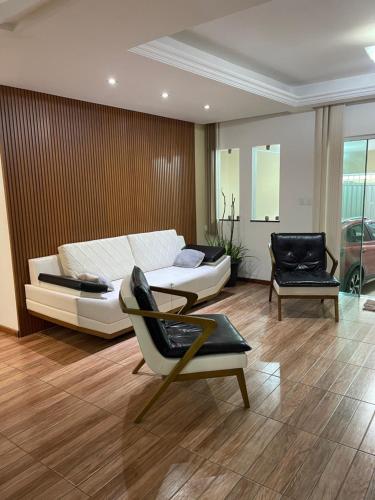 a bedroom with a bed and a couch and a chair at Residência Wimbledon in Ilhéus