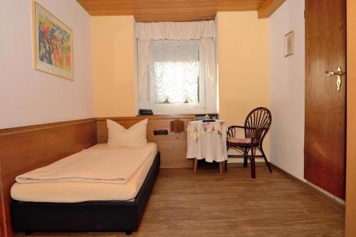 1 dormitorio con cama, mesa y ventana en Weinhaus Hotel zum Josefshof, en Graach
