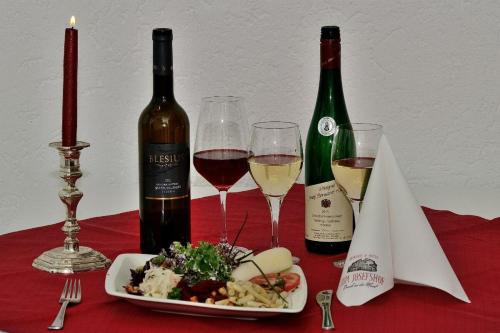 a table with two bottles of wine and a plate of food at Weinhaus Hotel zum Josefshof in Graach
