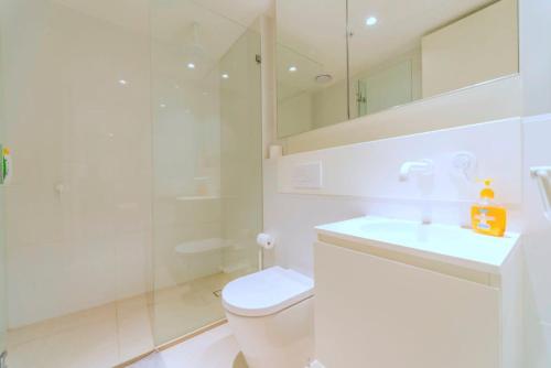 a bathroom with a toilet and a sink and a shower at Pride Manor South Yarra in Melbourne
