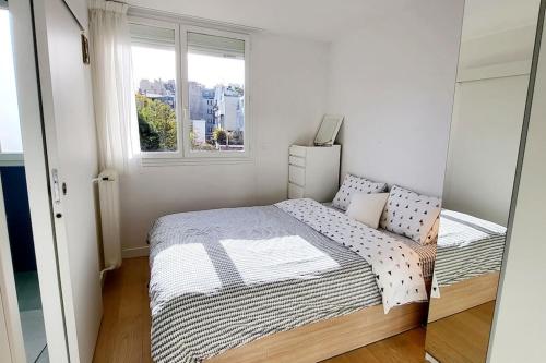 une petite chambre avec un lit et une fenêtre dans l'établissement Charming 2 bedrooms ideal for Olympic Games Paris!, à Boulogne-Billancourt