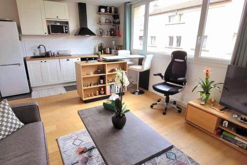 un salon avec un canapé et une table et une cuisine dans l'établissement Charming 2 bedrooms ideal for Olympic Games Paris!, à Boulogne-Billancourt