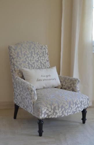 a pillow sitting on a chair in a room at Au Gré des Souvenirs, gite 4 à 10 pers, clim, jacuzzi, loisirs in Château-la-Vallière