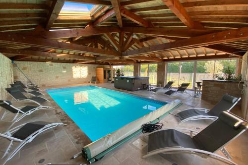 une grande piscine avec des chaises autour dans l'établissement Gîte de Couet, à Caumont