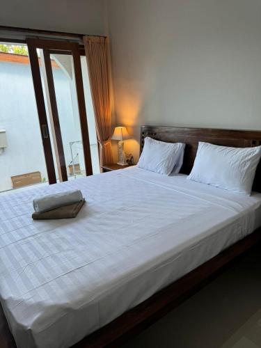a large white bed with a pillow on it at Simple Homestay Balangan in Jimbaran