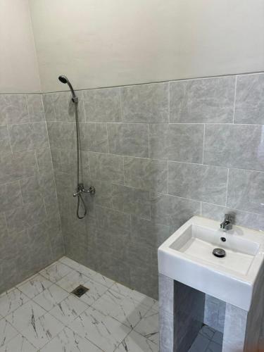 a bathroom with a white sink and a shower at Simple Homestay Balangan in Jimbaran
