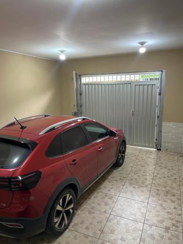 a red car parked in front of a garage at Residência Wimbledon in Ilhéus