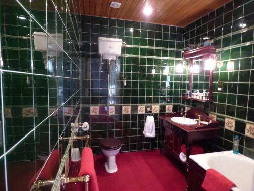 a green tiled bathroom with a toilet and a sink at Moorlands in Helensburgh