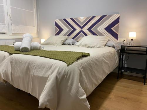 1 dormitorio con 1 cama grande con sábanas blancas en La Casa de Carola, en Bilbao