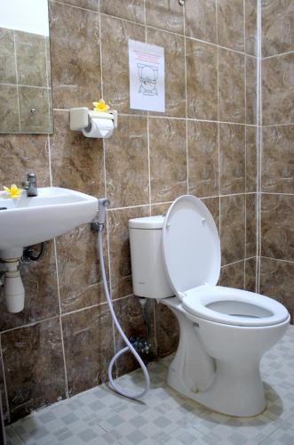 Djembank Hotel في Tjakranegara: حمام مع مرحاض ومغسلة