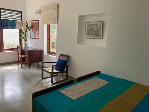 um quarto com uma cama, uma cadeira e uma mesa em Green Path em Colombo