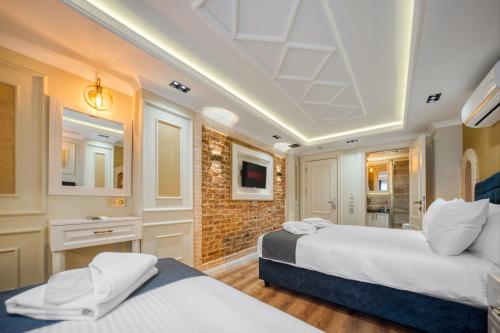 a bedroom with two beds and a brick wall at Mahhsen Mansion Oldcity in Istanbul