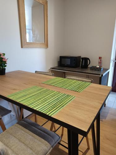 une table en bois avec des rayures vertes dessus dans une cuisine dans l'établissement Appartement des oliviers, à Les Ageux