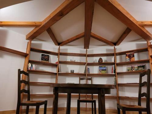 RevelにあるGrand Gites 6 personnes Uriage Chamrousse Grenobleのテーブル、椅子2脚、棚が備わるお部屋