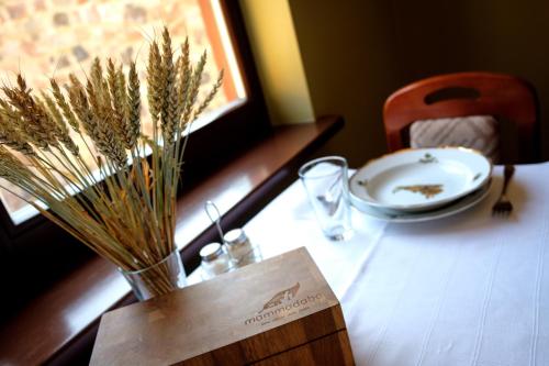 a table with a vase of dried flowers and a plate at LVM tūrisma un atpūtas centrs "Ezernieki" in Meirāni