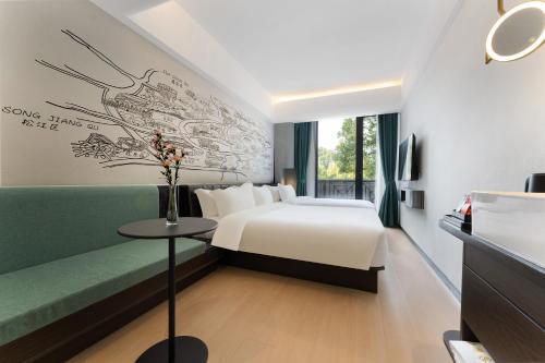 上海市にあるShanghai Pudong Xiangguo Hotelのベッドとソファ付きのホテルルーム