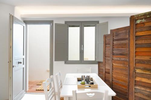 a dining room with a white table and chairs at Luna Rossa Milos - Lavender in Provatas