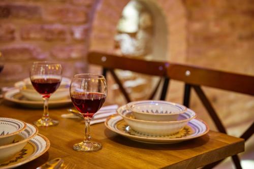 a wooden table with two glasses of red wine at Mahhsen Mansion Oldcity in Istanbul