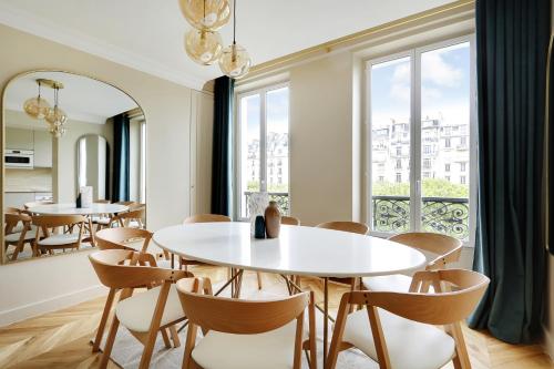 une salle à manger avec des tables et des chaises ainsi qu'une grande fenêtre dans l'établissement Pick A Flat's Apartment in Invalides - Avenue de Breteuil, à Paris