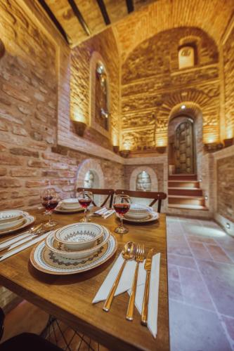a wooden table with plates and wine glasses on it at Mahhsen Mansion Oldcity in Istanbul