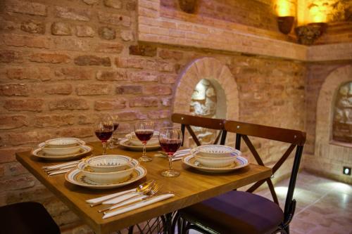 a wooden table with plates and glasses of wine at Mahhsen Mansion Oldcity in Istanbul