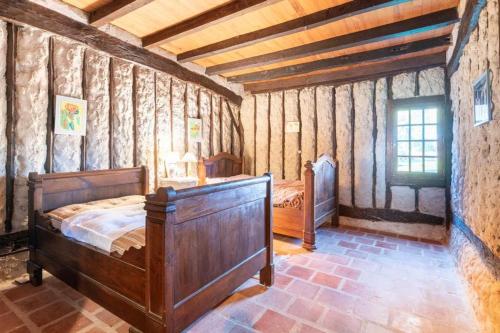 a bedroom with a bed in a room with wooden walls at Maison landaise avec jardin clos, idéal pour animaux in Lacquy