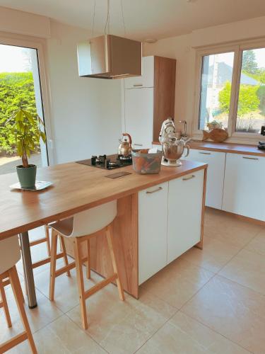 uma cozinha com um balcão de madeira e uma mesa em Maison de famille avec grand jardin, 2 chambres - proche centre-ville em Plouha